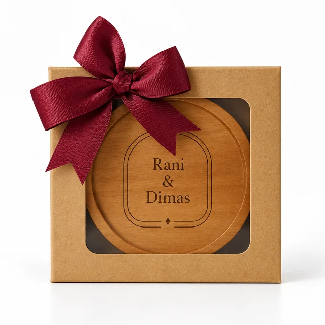 Tatakan kayu Rani & Dimas dalam box kraft berjendela dengan pita satin burgundy di latar putih.